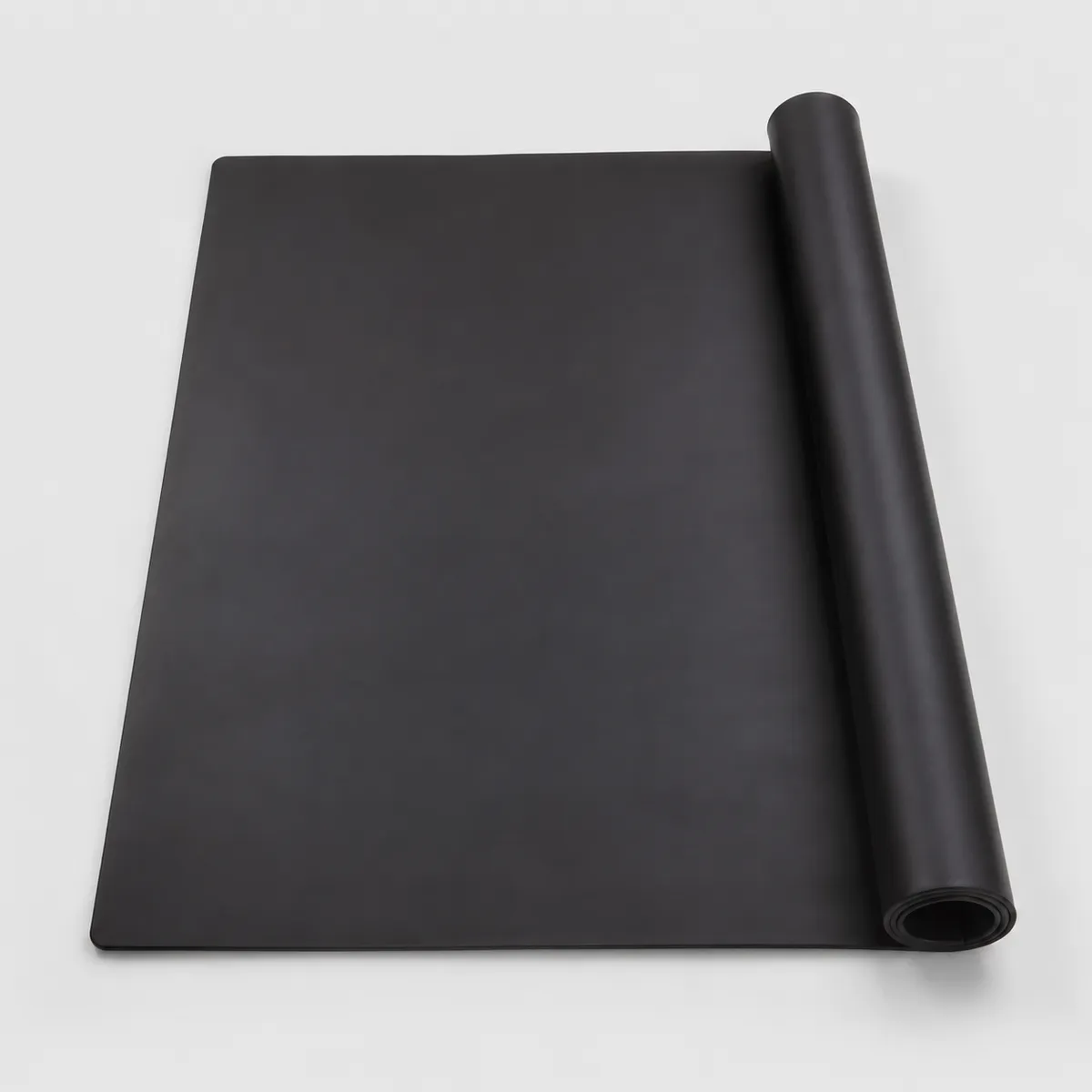 Black heat resistant silicone workbench mat with rolled edge on light gray background