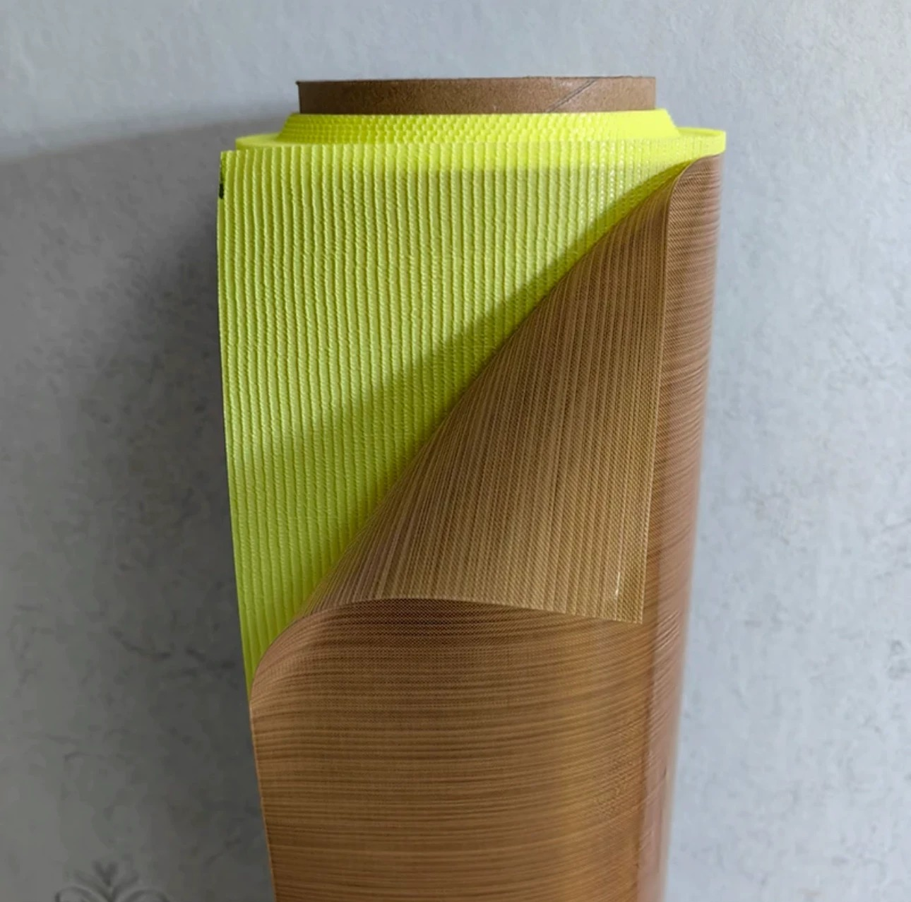 Adhesive-backed PTFE fiberglass fabric with its yellow protective release liner